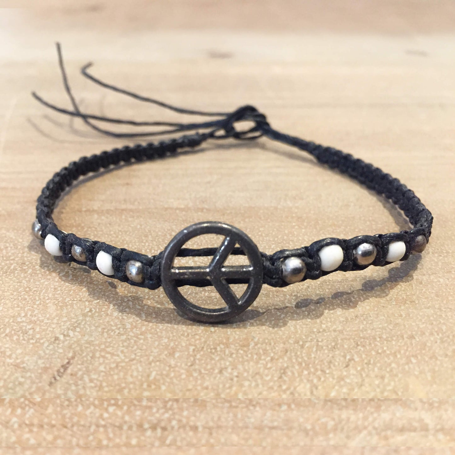 Pulsera tejida de hematita con símbolo de la paz